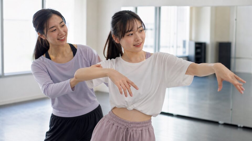 講師とダンスの基礎を練習する女性のイメージ